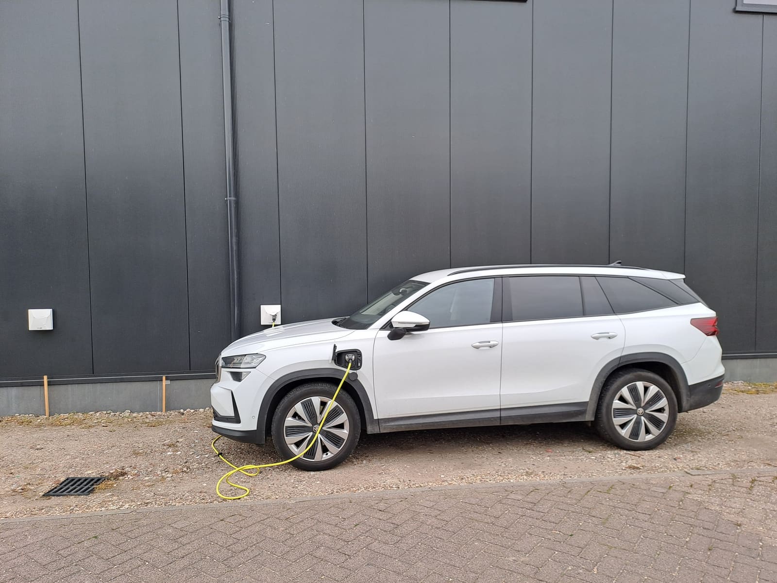 Elektrische auto aan het laadpunt bij de loods
